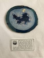 Top-down image showing the polished surface of the blue agate slice with detailed coloration and crystal formations