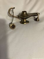 Front view of solid brass burning pot with lid off and wick exposed, showing chain connecting lid to handle.