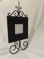 Front view of black metal picture frame showing ornate scrollwork and 3x3 inch picture opening.