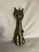 Front view of the solid brass cat figurine showing etched design and facial details