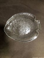 Top down view showing detailed fish scale texture and raised features on glass serving plate