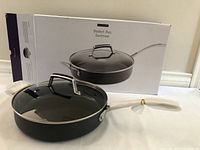 Perfect Pan Sauteuse frying pan with glass lid, black finish, metal handle, placed in front of box packaging
