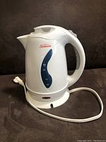 White Sunbeam electric kettle with 1.7 litre capacity, power base with cord shown on dark background.