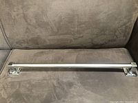 Full view of the stainless steel towel bar showing its length and rectangular mounting brackets on each end.