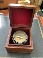 Compass inside wooden box with red felt lining