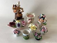Front view of all ceramic figurines and decorative items in the lot on a plain background.