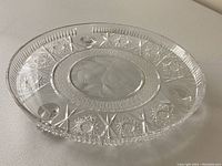 Full view of the clear crystal serving platter showing the cut patterns around the rim.
