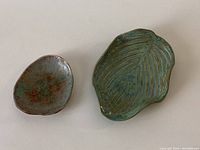 Top view of two hand-formed pottery dishes showing glaze colors and shapes