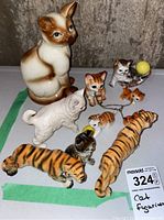 Overhead photo showing all ten ceramic cat figurines together with mix of colors and sizes.