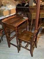 Wood desk and matching chair set seen from an angle, showing the overall shape and wooden finish.