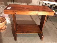 Front view of a wooden hall table showing the top surface and lower shelf with curved legs.