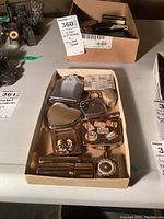 Various pill boxes and compacts including heart-shaped, rectangular with stickers, and metal compacts with gemstone-style decorations arranged in a container.