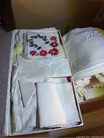 Small handkerchief box containing folded embroidered and crocheted linens