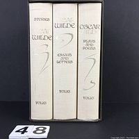 Spines of three volumes housed in original slipcase with lot number card visible