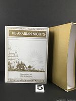 Front cover of 'The Arabian Nights' book with slipcase showing title and illustration credits to Detmold.