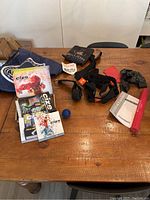 Overview of all exercise items including bands, workout DVDs, stretch strap, Acuball, and Sketchers navy backpack