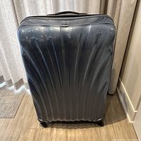 Front view of Samsonite C-Lite suitcase upright showing wave-patterned shell and wheel base