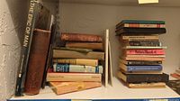 Two shelves of assorted hard and soft cover books. Titles visible include 'The Epic of Man,' 'The Sage of Sex,' and 'Federal Blocks.'