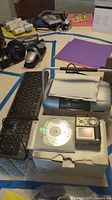 Photo showing keyboard, headphones, digital camera, paper, and the Canon Picture Mate printer.