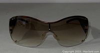 Front view of Giorgio Armani sunglasses with brown gradient lenses and partial rimless design