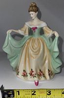 Front view of the Royal Albert Mary figurine showing detailed dress and floral accents with measuring tape for scale.