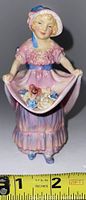 Front view of Royal Doulton Lucie Ann figurine in pink dress holding skirt with floral detail