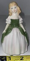 Front view of Royal Doulton Penny HN2338 porcelain figurine with green bodice and white skirt, showing detailed face and ruffled sleeves, size approximately 4 inches tall.