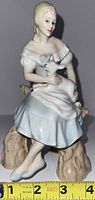 Front view of the Royal Doulton Shepherdess figurine holding a lamb, showing delicate features and color.