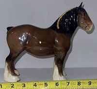 Side view of the brown and black Beswick horse figurine with white markings, showing detail and measurement of nearly 7.5 inches long.