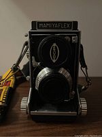 Front view without flash showing brand nameplate, dual lens configuration and lens caps