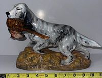 Side view showing full profile of the porcelain hunting dog on base, tape measure indicating approximately 11 inches long.