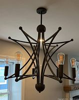 Main view of chandelier showing the six bulbs and curved metal frame.