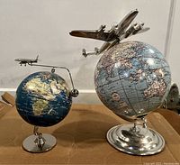 Overview of two balancing desk globes with airplane figures on a tabletop