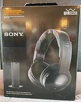 Front of unopened box showing the Sony wireless stereo headphones with padded headband and ear cushions, and separate wireless transmitter base.