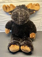 Front view of plush moose bed warmer showing detailed face, antlers, and soft paws.