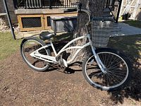 Full side view of white Electra Cruiser 1 bicycle leaning against tree outdoors