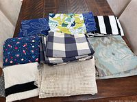 Overview of assorted fabric pieces displaying different colors and patterns on a wooden table.