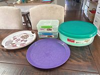 Cake carrier, bento boxes, and serving trays arranged on table