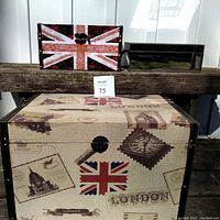 Photo showing three British themed storage boxes on a wooden surface, largest box with London motifs, smaller floral Union Jack box and mirrored box with bus image visible