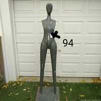 Front view of the full mannequin showing overall shape, color, extensive paint chipping and rectangular base.