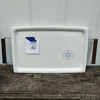 Front of white rectangular Corningware platter on metal and wood stand.