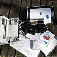 Fujitsu fi-6130 scanner, cables, manuals, extra ink cartridge, and software CDs laid out on wooden surface.