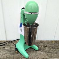 Full view of the green retro Hamilton Beach milkshake mixer with its stainless steel mixing cup and power cord.