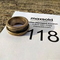 Angle showing ring placed on auction lot card, highlighting shape and size