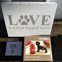 Wooden paw print sign reading 'LOVE is a four legged word' with the original Pier 1 Imports salt and pepper shaker box beside it.