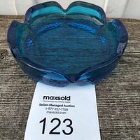Side view of the vintage blue glass floral lotus ashtray showing its shape and color