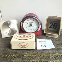 Four vintage decor pieces on wooden surface: Taylor thermometer, Kodak timer, perpetual calendar, and Pears soap box.
