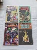 Four comic books laid out on white cloth: 'Married with Children' (Now Comics), 'The Twisted Tales of Bruce Jones' Part 1 and Part 4 (Eclipse Comics), and 'Wildstorm Rising' (Image Comics)