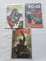 Three Dark Horse Presents 100 comic books with different cover art laid out together