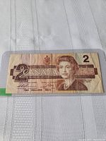 Front view of the 1986 Canadian $2 banknote showing Queen Elizabeth II and denomination details.